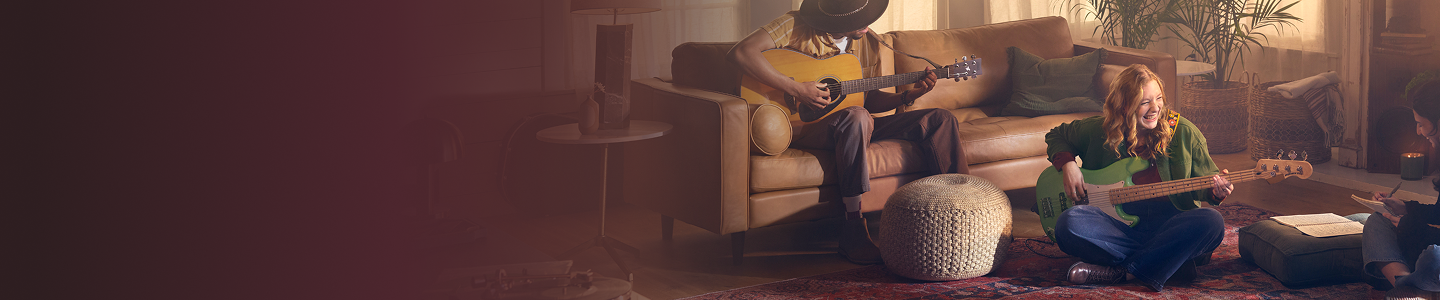 Two people playing guitar in a living room