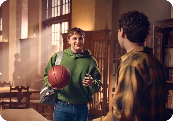 Student in a library holding a basketball
